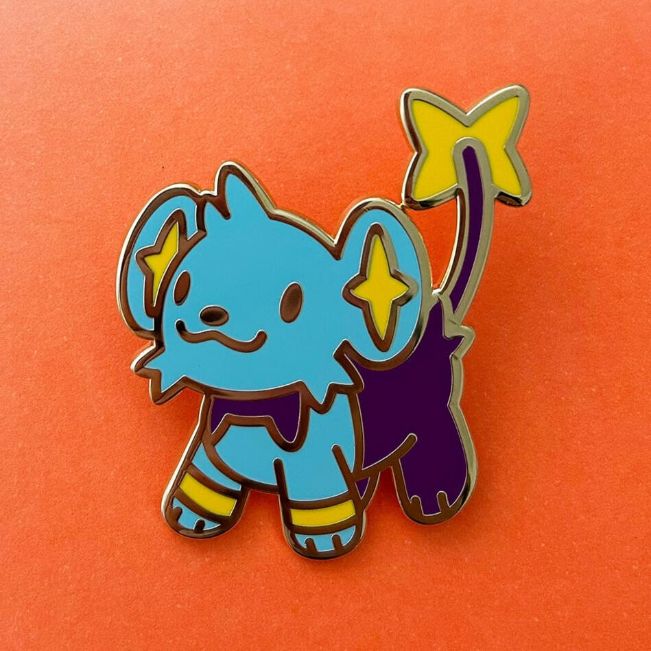 Photograph of a Shinx Pokémon enamel pin over an orange background.