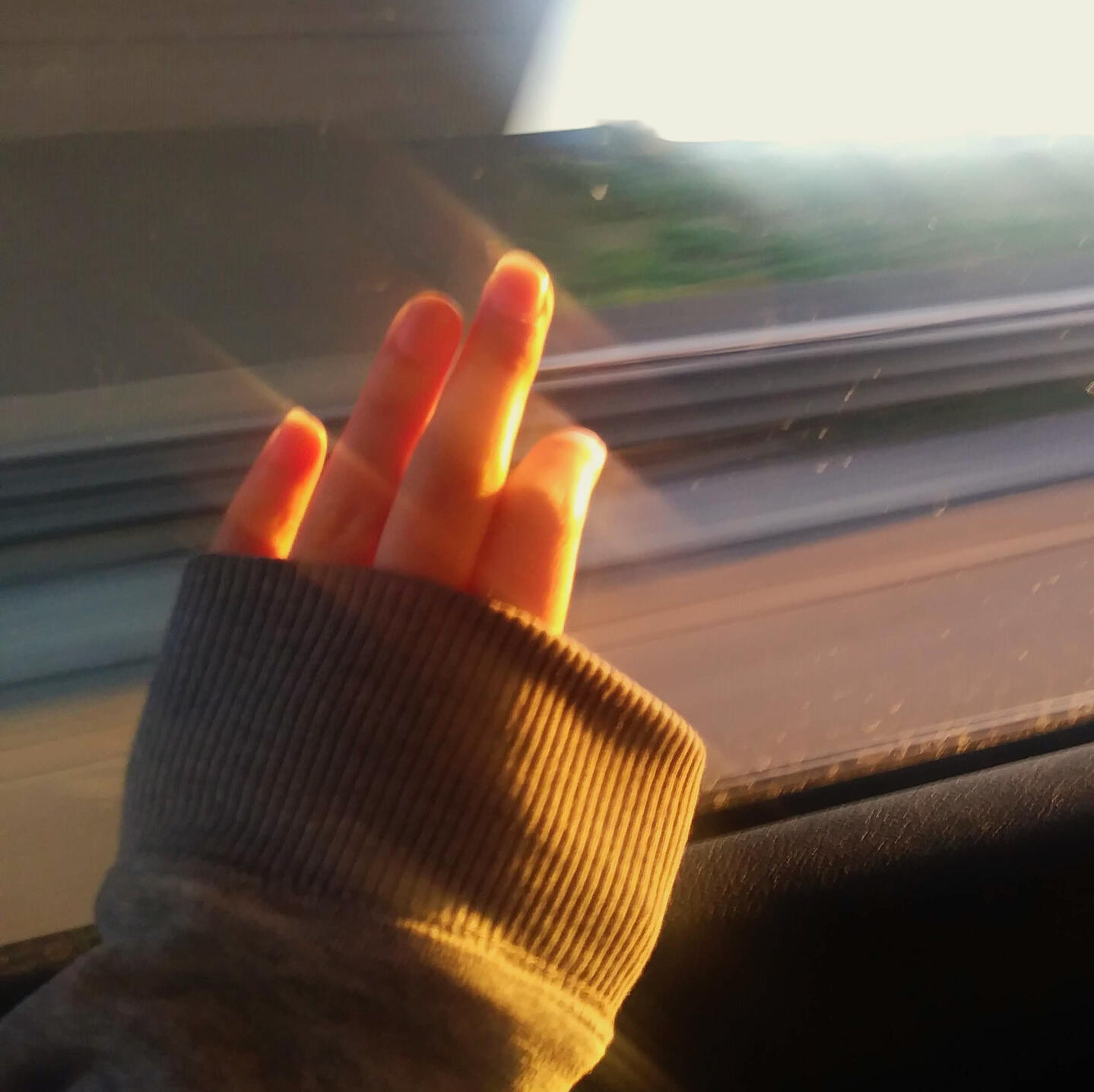 The moonysolar representative photo. A hand against the window during golden hour.